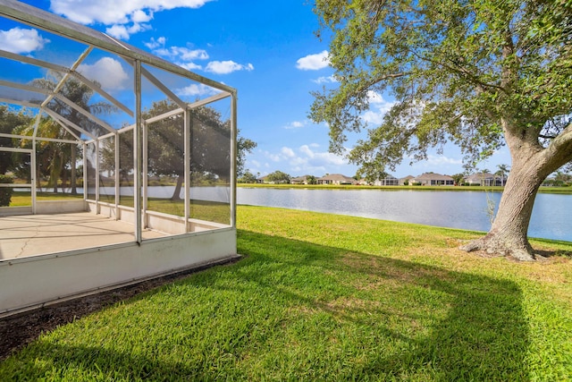 view of yard with glass enclosure and a water view