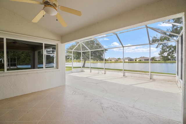 unfurnished sunroom with ceiling fan, a water view, and lofted ceiling