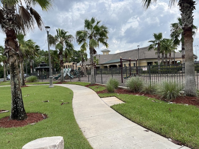 view of home's community with a playground and a lawn