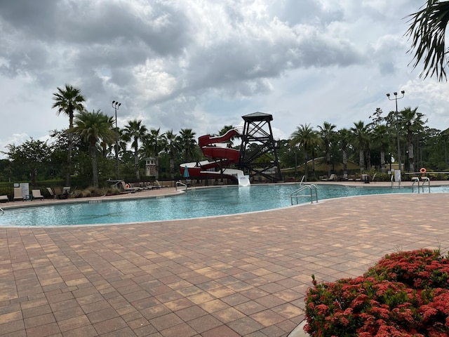 view of pool with a patio area and a water slide