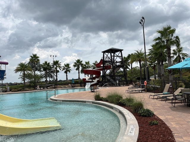 view of pool with a patio and a water slide