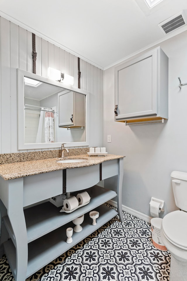 bathroom featuring tile patterned flooring, a shower with curtain, toilet, and vanity