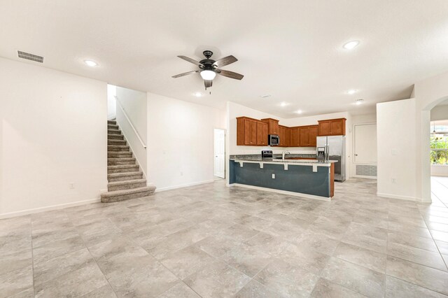 unfurnished living room with ceiling fan and sink