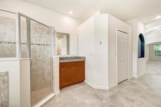 bathroom featuring walk in shower, ceiling fan, and vanity