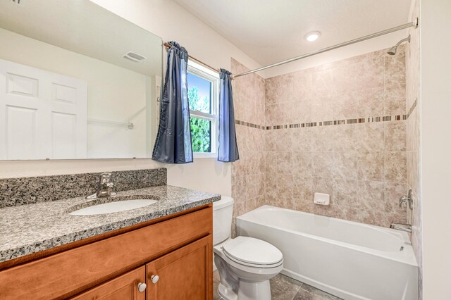 full bathroom featuring vanity, tiled shower / bath combo, and toilet