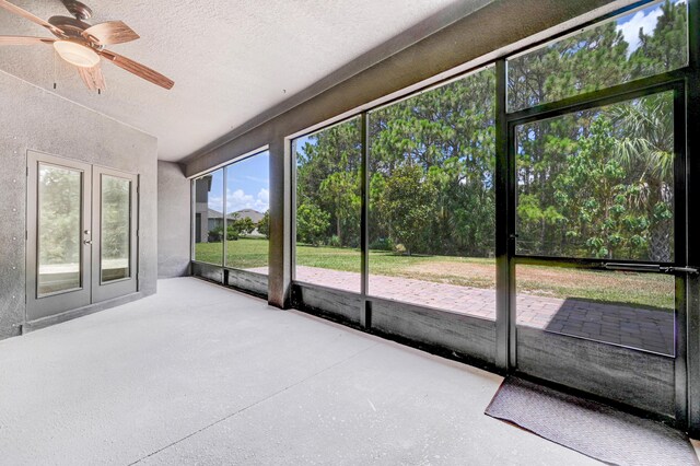 unfurnished sunroom featuring ceiling fan