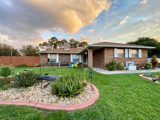 single story home featuring a lawn