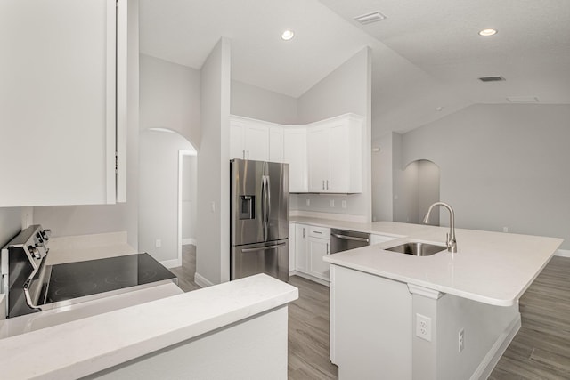 kitchen with sink, stainless steel appliances, lofted ceiling, white cabinets, and light wood-type flooring