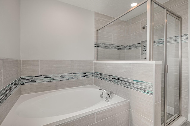 bathroom featuring shower with separate bathtub