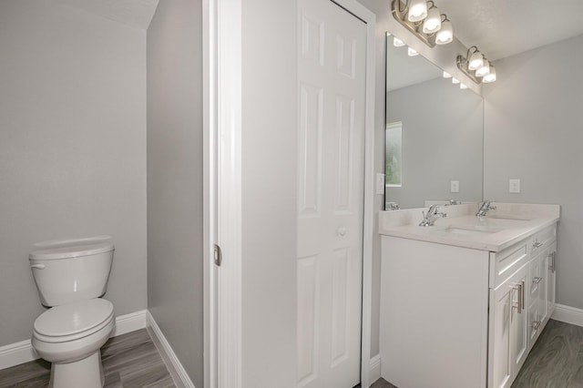 bathroom featuring a textured ceiling, vanity, hardwood / wood-style flooring, and toilet