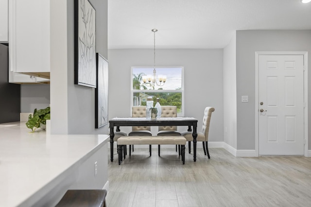 dining area featuring an inviting chandelier and light hardwood / wood-style flooring