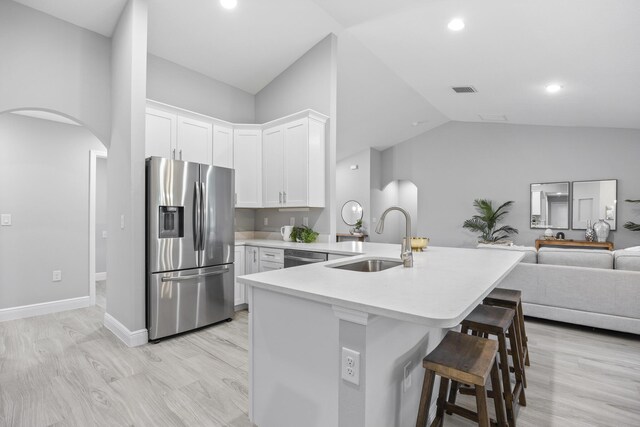 kitchen with white cabinets, stainless steel fridge with ice dispenser, lofted ceiling, and sink