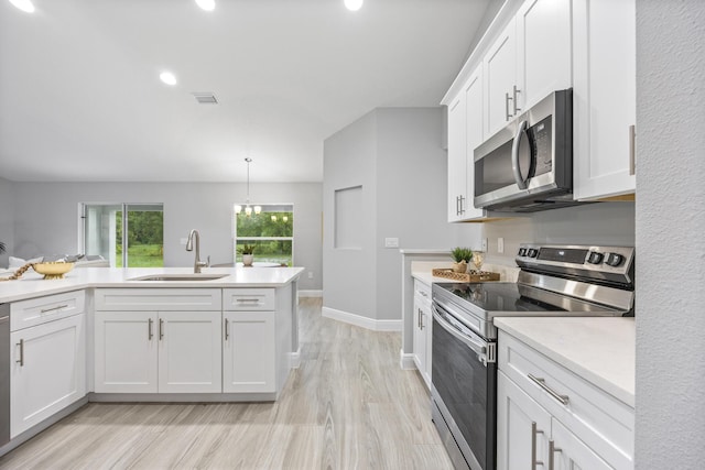 kitchen with pendant lighting, sink, light hardwood / wood-style flooring, stainless steel appliances, and white cabinets