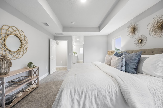 bedroom with a tray ceiling and carpet flooring