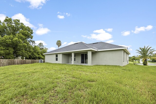 back of house featuring a lawn