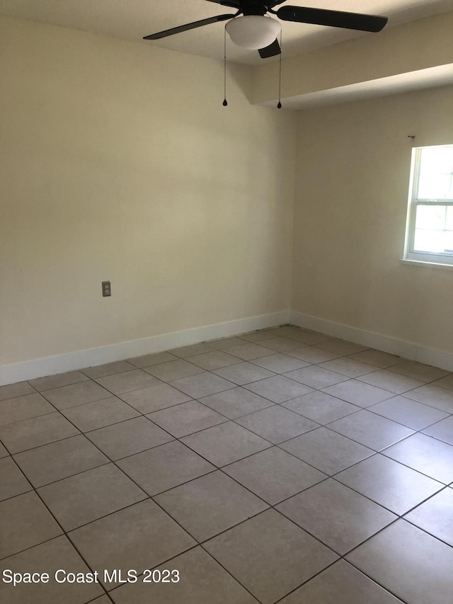 tiled spare room featuring ceiling fan