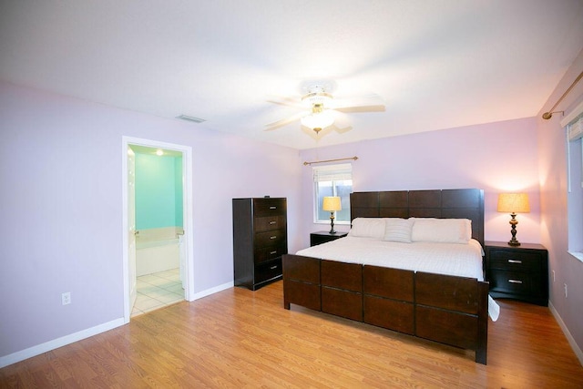 bedroom with ceiling fan, light wood-type flooring, and ensuite bathroom