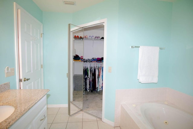 bathroom with vanity, tile patterned floors, and tiled tub