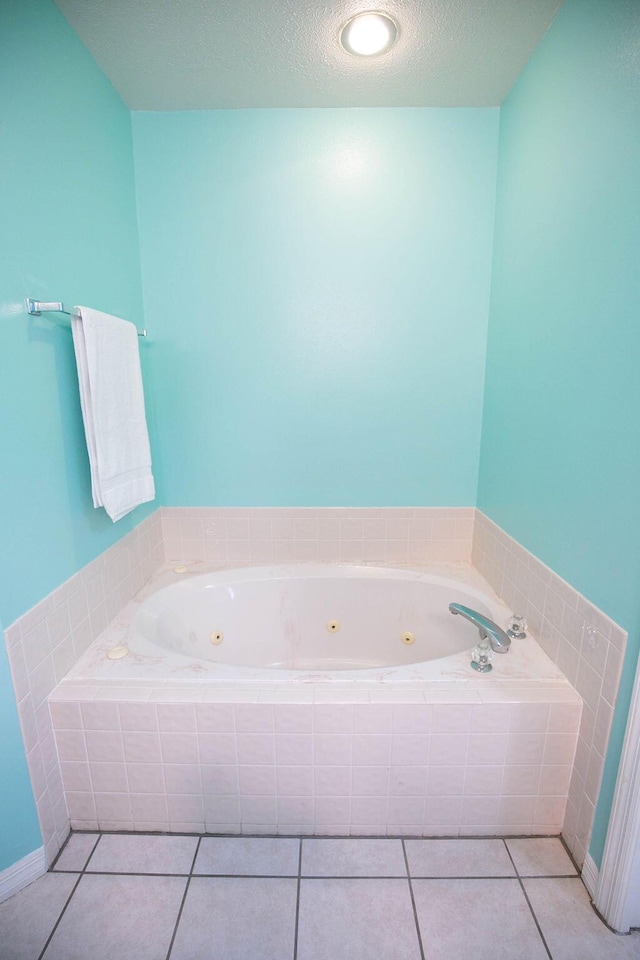 bathroom with tile patterned flooring, a textured ceiling, and tiled bath