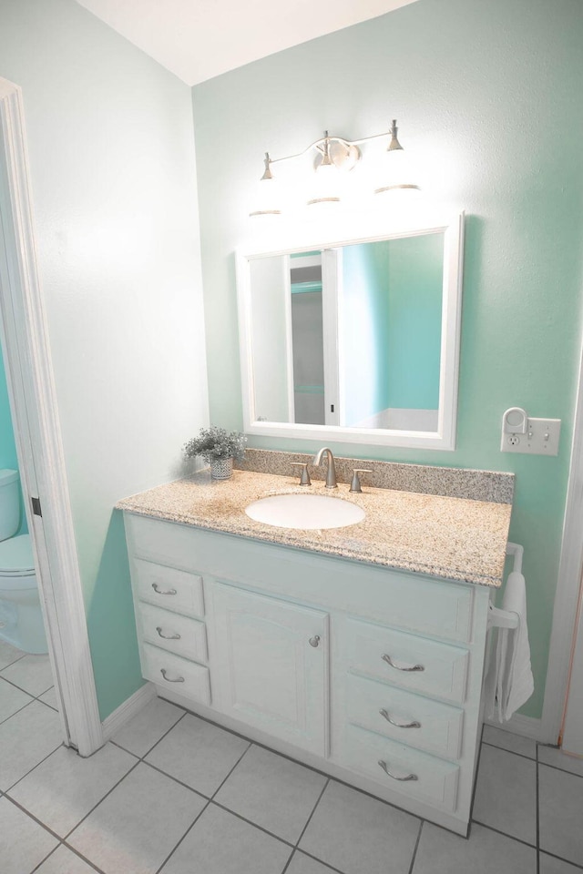 bathroom with tile patterned flooring, vanity, and toilet