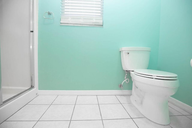 bathroom with toilet, tile patterned floors, and a shower with shower door