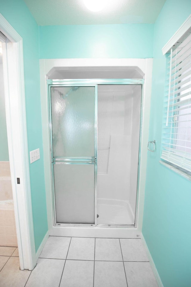 bathroom with tile patterned flooring and a shower with shower door