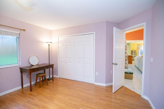 bedroom with light hardwood / wood-style floors and a closet