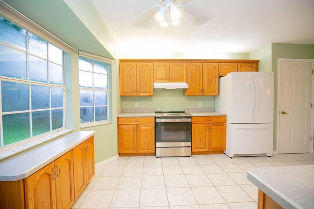 kitchen featuring light tile patterned floors, white fridge, ceiling fan, and stainless steel range oven