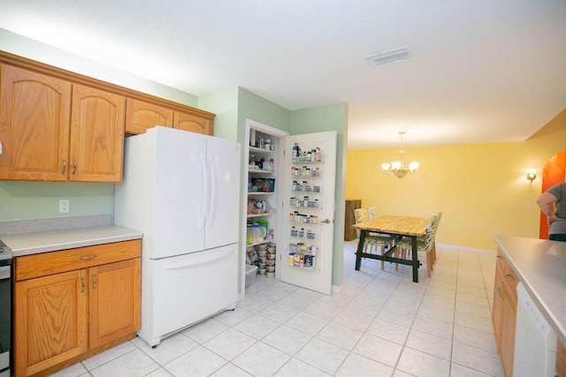 kitchen featuring light tile patterned flooring, decorative light fixtures, white appliances, and a notable chandelier