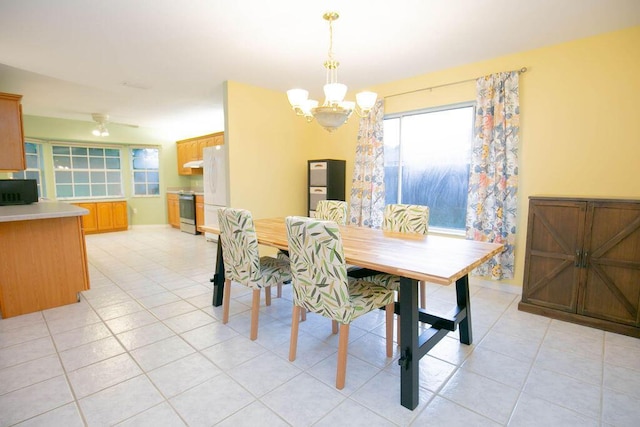 tiled dining area featuring ceiling fan with notable chandelier