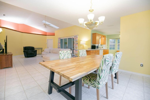 dining space with light tile patterned floors, ceiling fan with notable chandelier, and vaulted ceiling