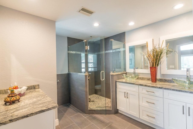 bathroom featuring vanity and an enclosed shower