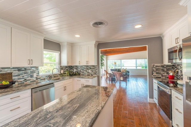 kitchen featuring light stone countertops, appliances with stainless steel finishes, dark hardwood / wood-style flooring, sink, and white cabinets