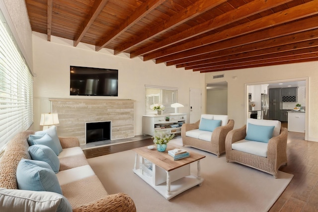 living room featuring hardwood / wood-style flooring, beam ceiling, wood ceiling, and a fireplace