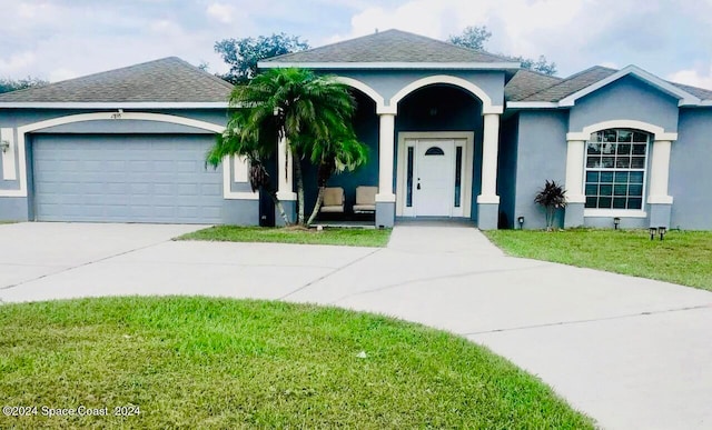 single story home featuring a front yard and a garage