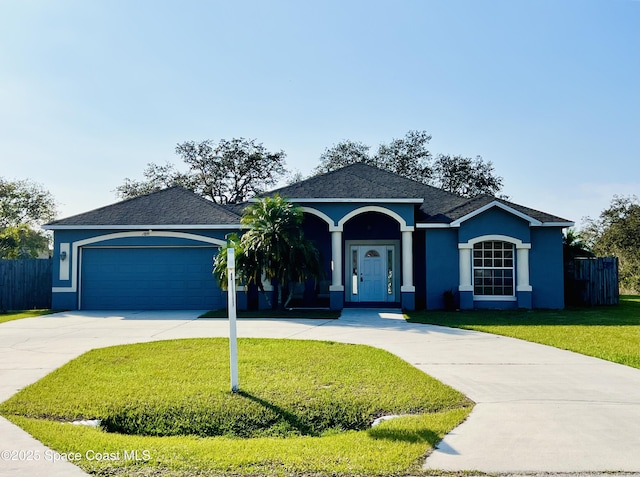 ranch-style house featuring a front lawn, fence, stucco siding, a garage, and driveway