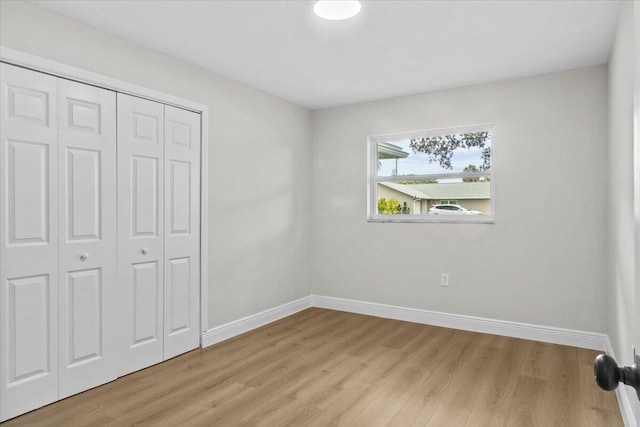 unfurnished bedroom featuring a closet and light hardwood / wood-style flooring