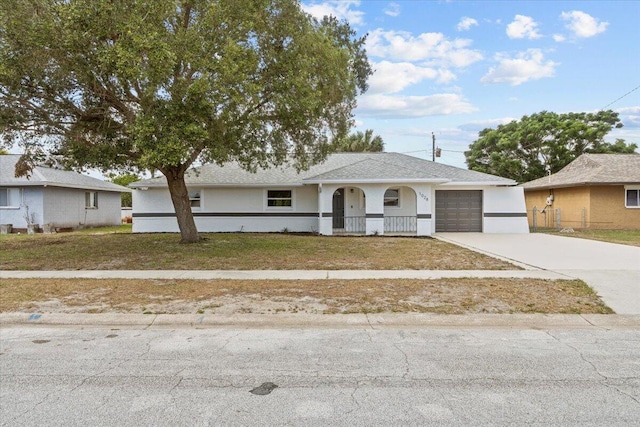 single story home with a porch, a garage, and a front lawn