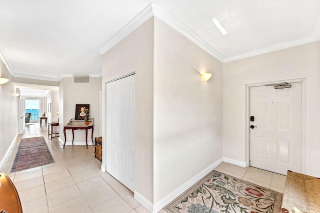 tiled entrance foyer featuring crown molding