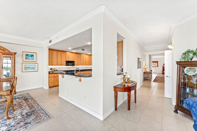 kitchen with a breakfast bar, light tile patterned floors, kitchen peninsula, and crown molding