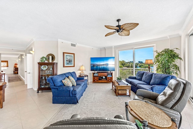 living room featuring light tile patterned floors, a textured ceiling, ceiling fan, and ornamental molding