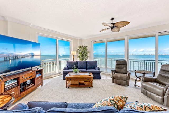 tiled living room featuring ceiling fan, crown molding, a water view, and a textured ceiling