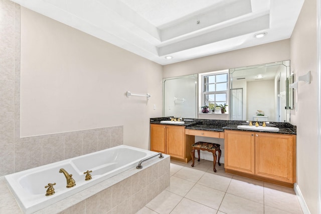 bathroom featuring tile patterned floors, vanity, and a relaxing tiled tub