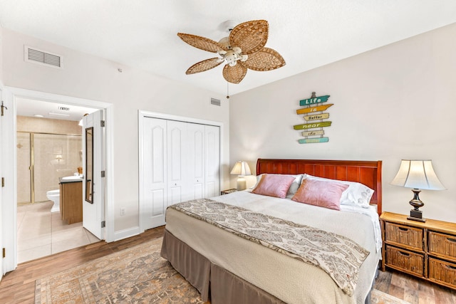 bedroom featuring ensuite bath, ceiling fan, a closet, and wood-type flooring