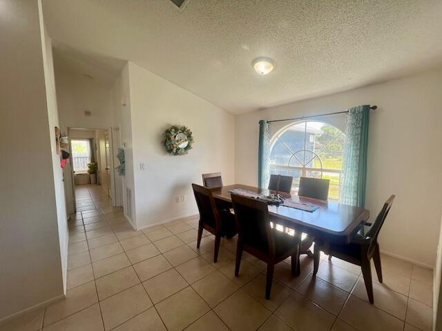 tiled dining area featuring a healthy amount of sunlight and a textured ceiling