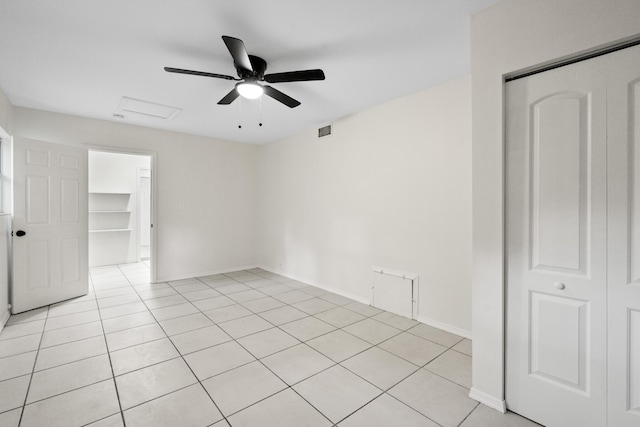 tiled spare room featuring ceiling fan