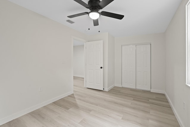 unfurnished bedroom featuring a closet, light hardwood / wood-style flooring, and ceiling fan