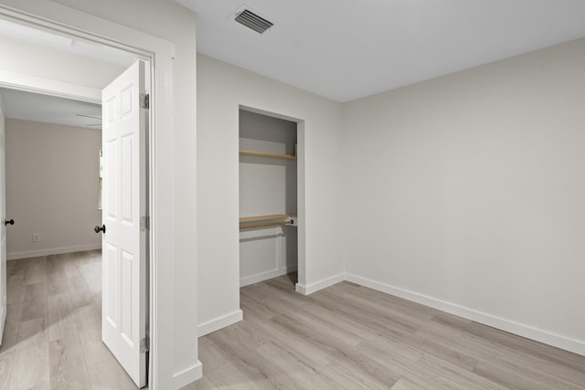 unfurnished bedroom with light hardwood / wood-style floors and a closet