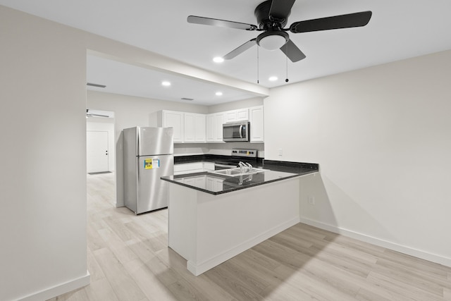 kitchen with kitchen peninsula, white cabinetry, ceiling fan, and stainless steel appliances