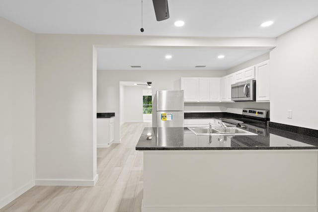 kitchen with kitchen peninsula, stainless steel appliances, sink, light hardwood / wood-style flooring, and white cabinets